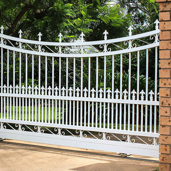 White wrought iron driveway entrance gates in brick fence Brama przesuwna